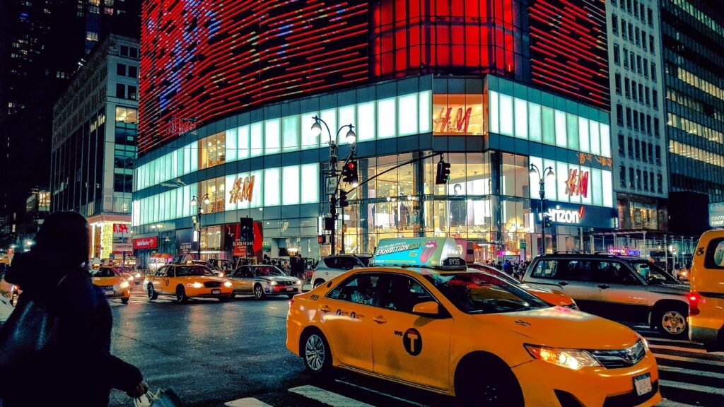 Dynamic night scene in Times Square with traffic and illuminated buildings.