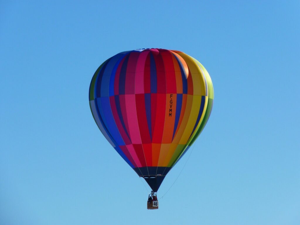 Colorful hot air balloon soaring high in a clear blue sky, capturing a sense of adventure and freedom.